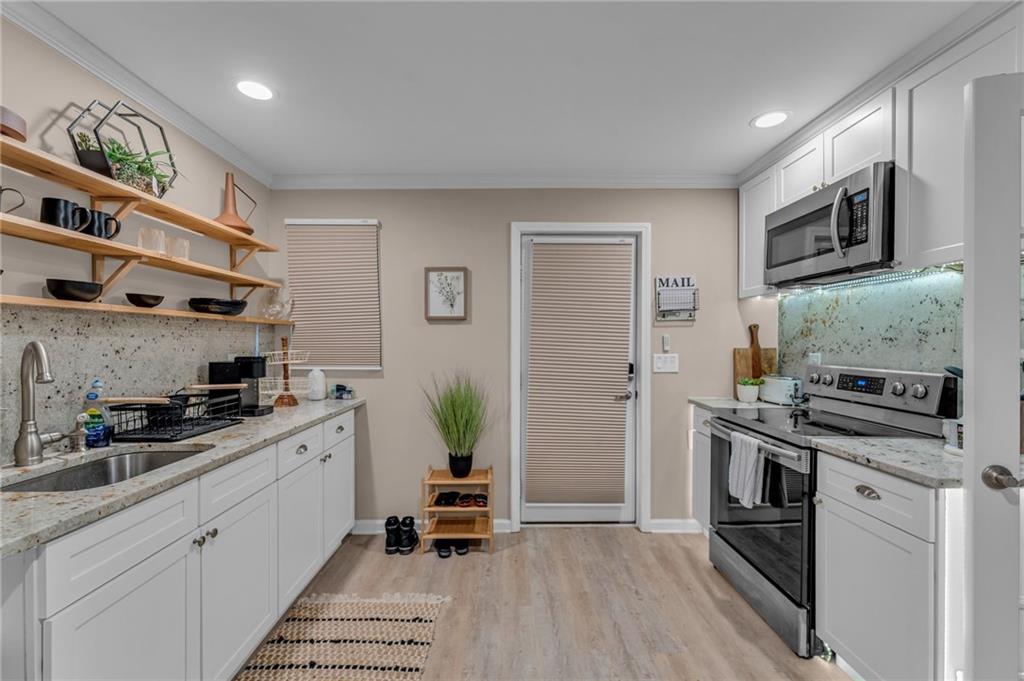1093 3rd Street Stone Mountain, GA 30083 - Photo 27 of 43 a kitchen with stainless steel appliances a stove a sink and a refrigerator