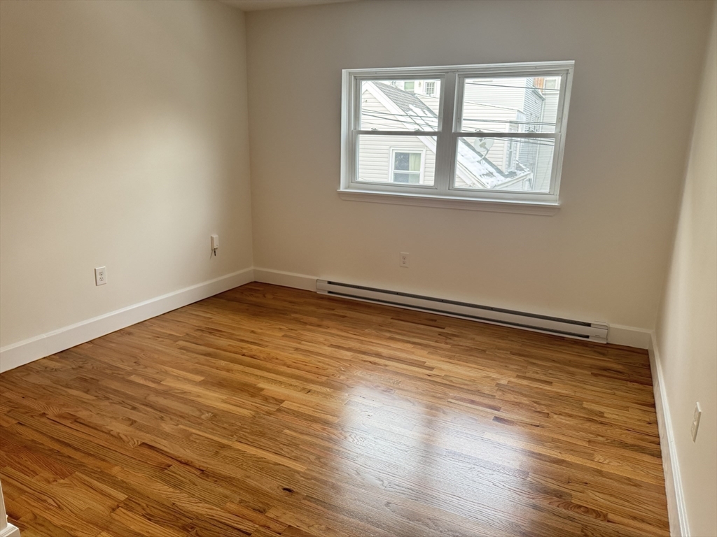 13 Murray Court, Unit 1 Boston, MA 02128 - Photo 11 of 22 a view of empty room with wooden floor and fan