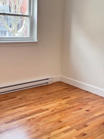 a view of a room with wooden floor and a window