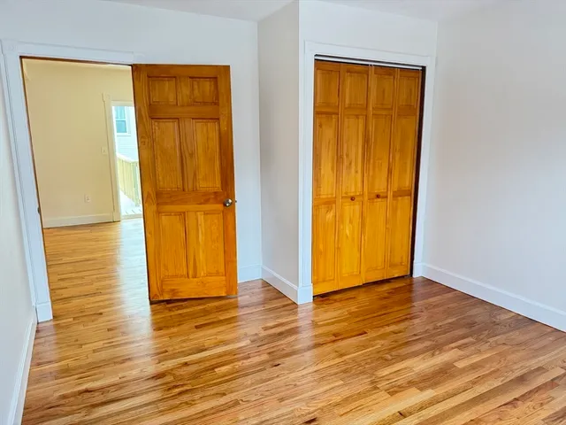 an empty room with wooden floor and door