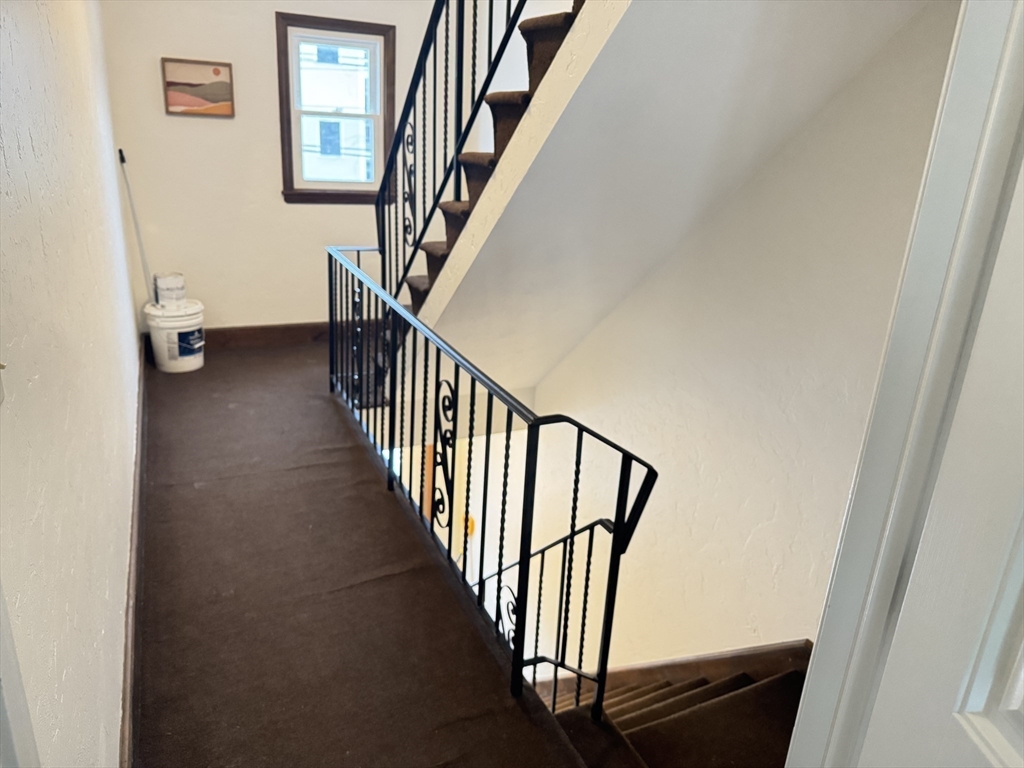 13 Murray Court, Unit 1 Boston, MA 02128 - Photo 18 of 22 a view of staircase with lots of frames on wall and a window