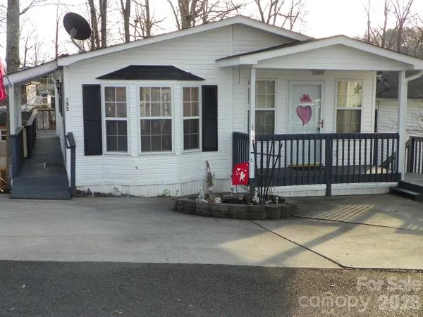 a view of a house with a small yard and wooden fence