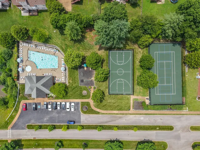 an aerial view of a residential apartment building with a yard and garage