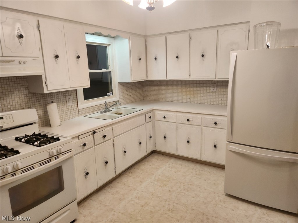 4516 Warner Road Cleveland, OH 44105 - Photo 30 of 30 Kitchen with white appliances, sink, tasteful backsplash, and white cabinetry