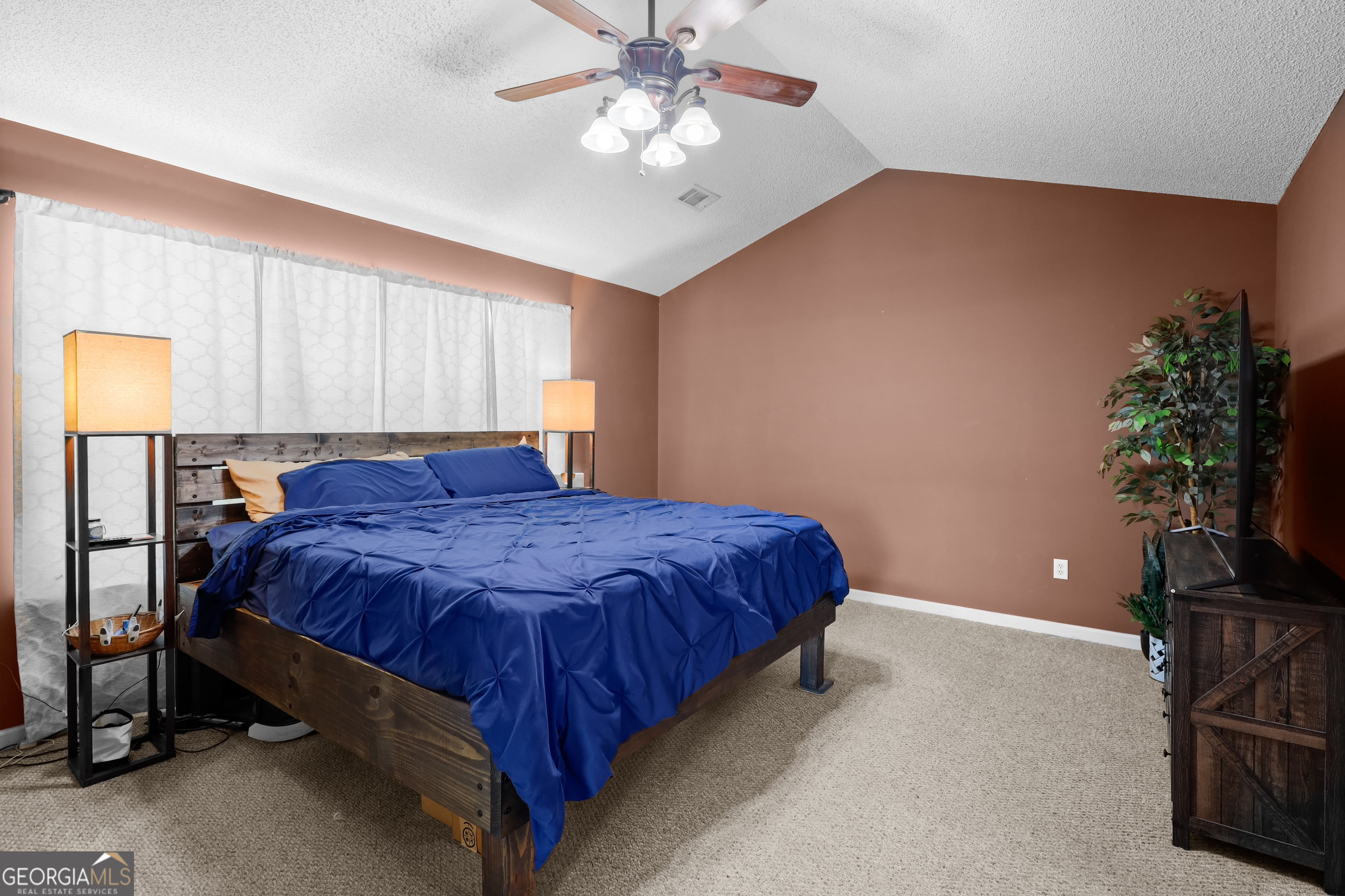 136 Quail Knoll Road Danville, GA 31017 - Photo 18 of 49 a spacious bedroom with a bed and a potted plant