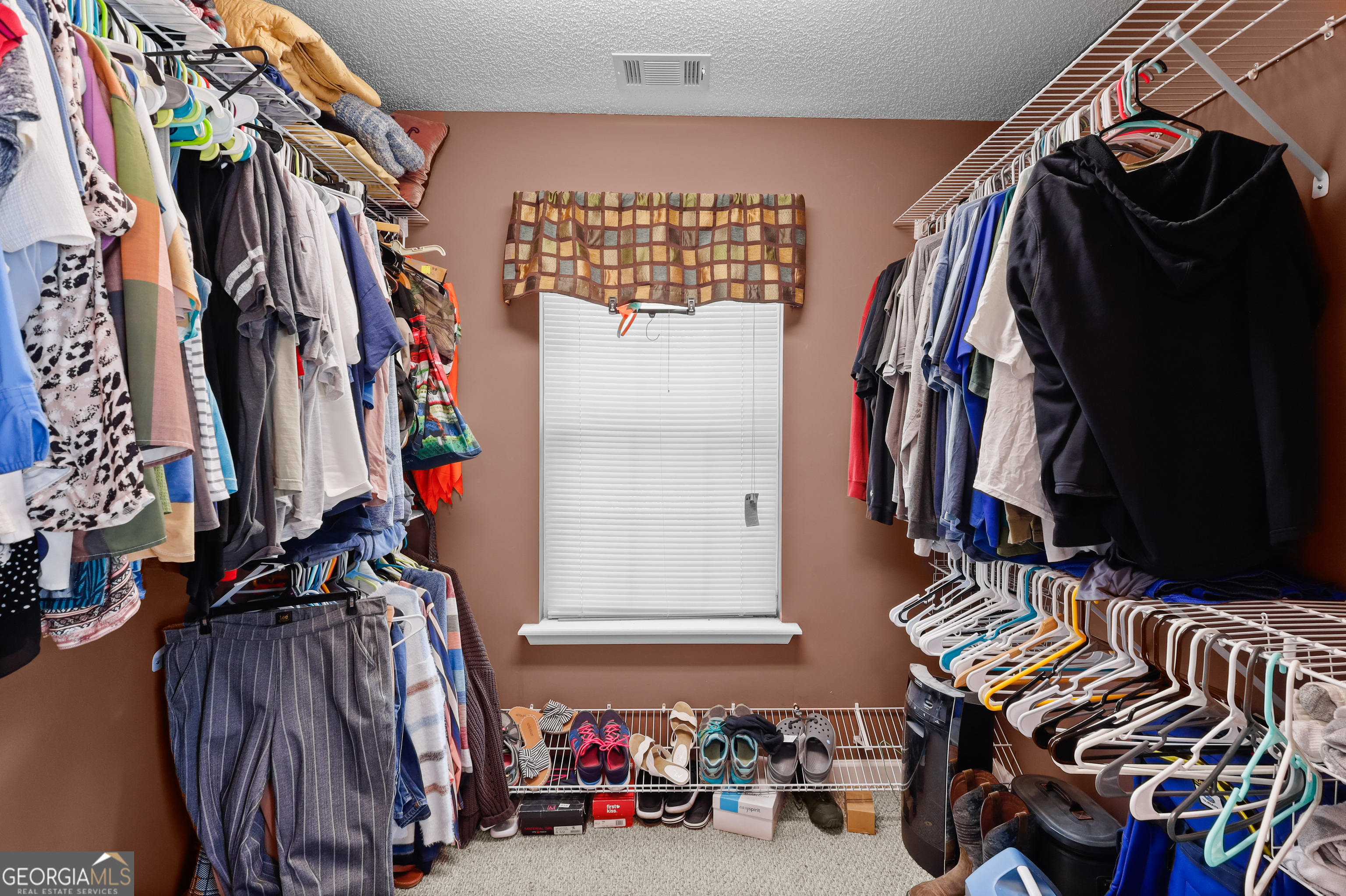 136 Quail Knoll Road Danville, GA 31017 - Photo 22 of 49 a view of walk in closet with clothes and shoes