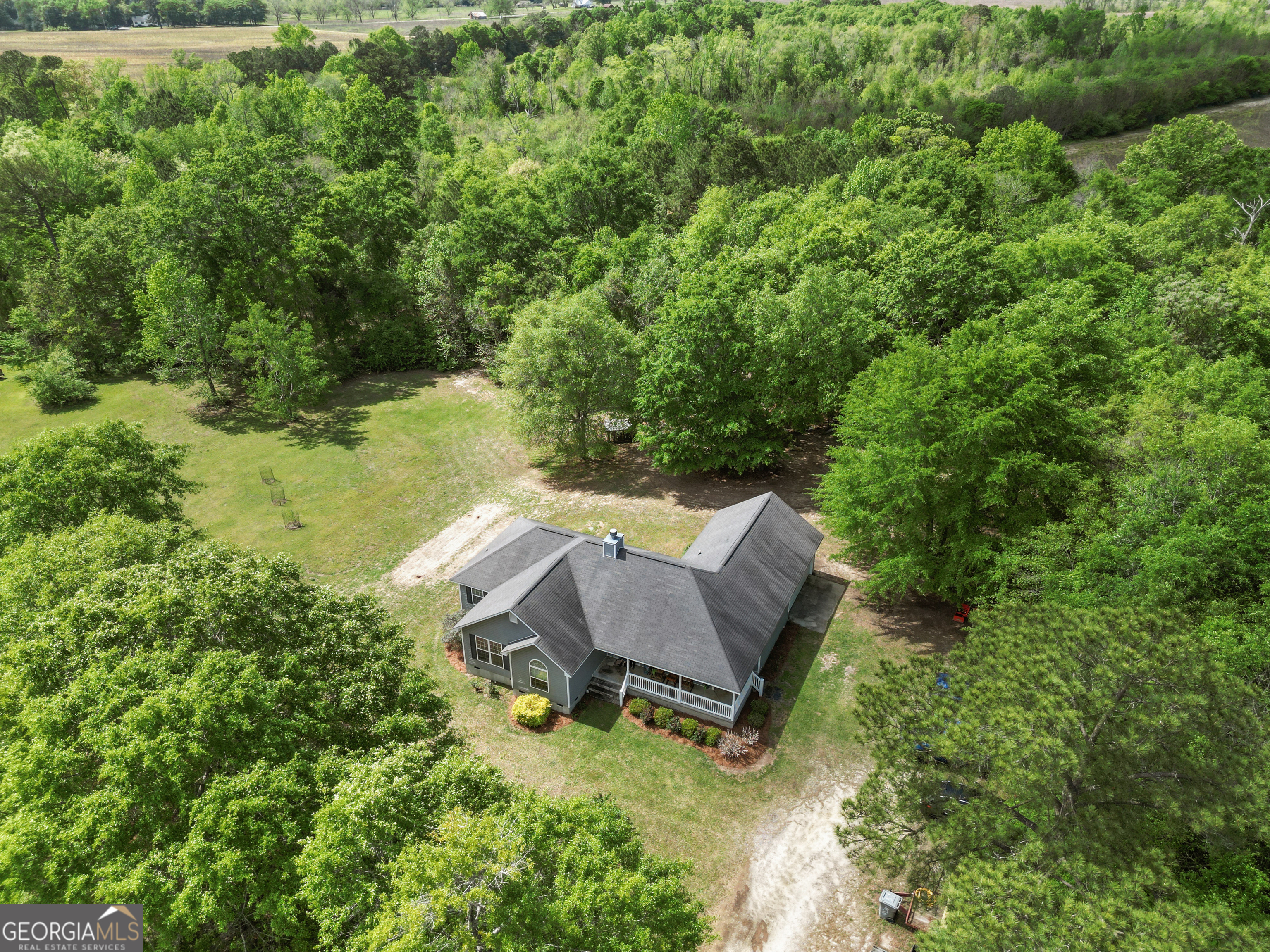 136 Quail Knoll Road Danville, GA 31017 - Photo 36 of 49 a view of a backyard with couches plants and large trees