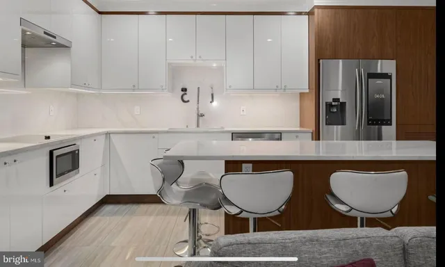 a kitchen with cabinets and chairs