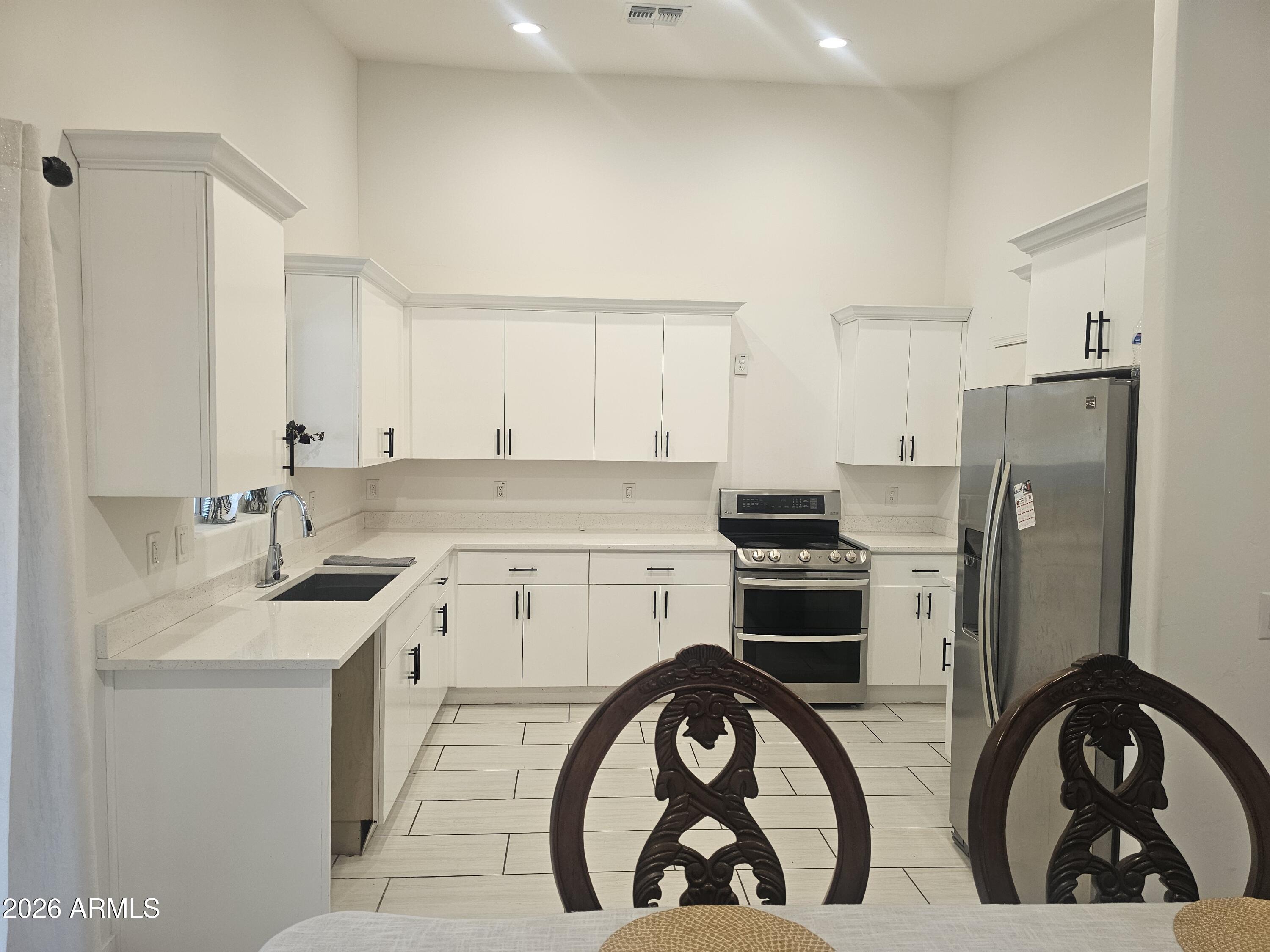 3021 West Almeria Road Phoenix, AZ 85009 - Photo 5 of 17 a kitchen with stainless steel appliances a stove a sink and a refrigerator