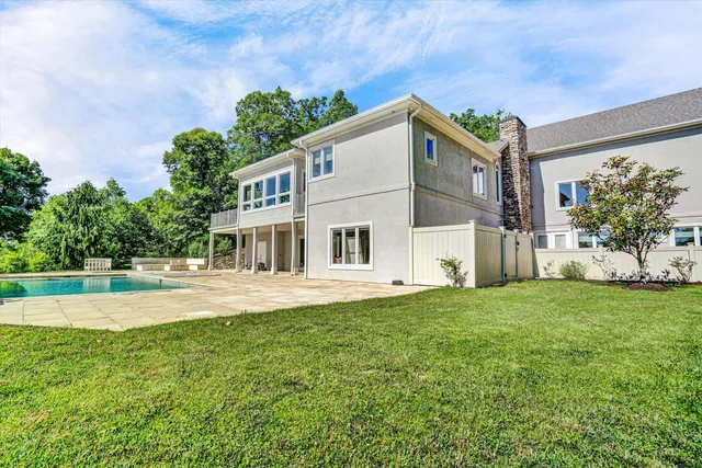 a kitchen with granite countertop stainless steel appliances a refrigerator a stove a dining table and chairs with wooden floor