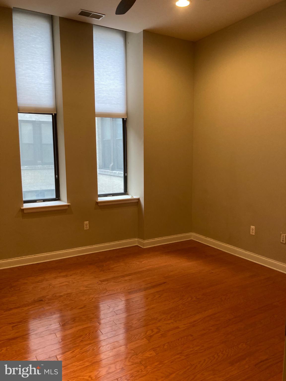1001-13 Chestnut Street, Unit 705W Philadelphia, PA 19103 - Photo 12 of 30 a view of an empty room with wooden floor and a window