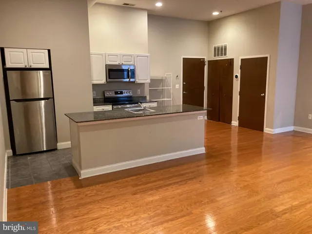 a kitchen with stainless steel appliances a refrigerator and a stove top oven