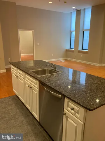a kitchen with granite countertop a sink and cabinets