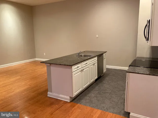 a kitchen with granite countertop a stove and a refrigerator