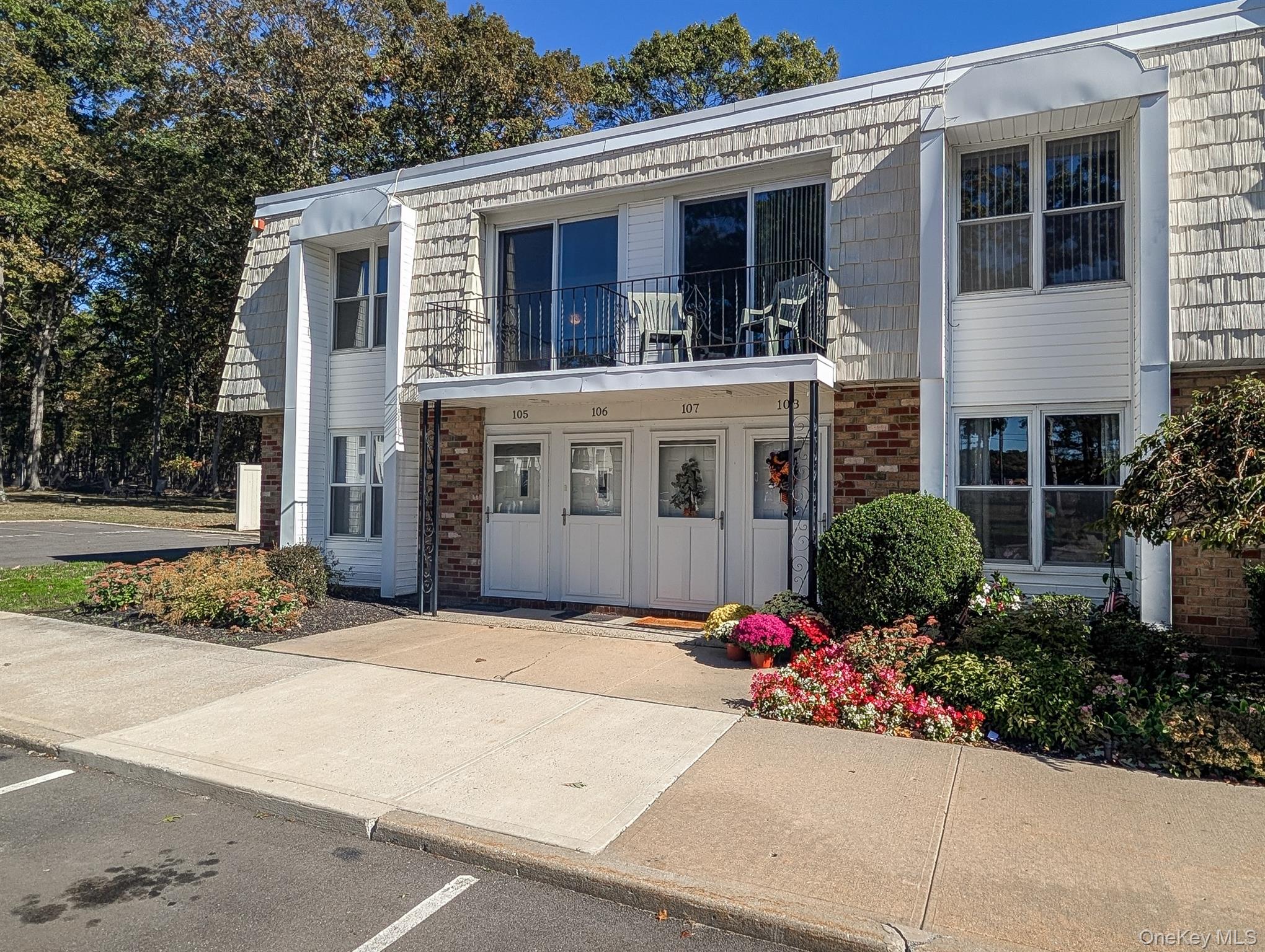 View of front of property with a balcony and brick siding