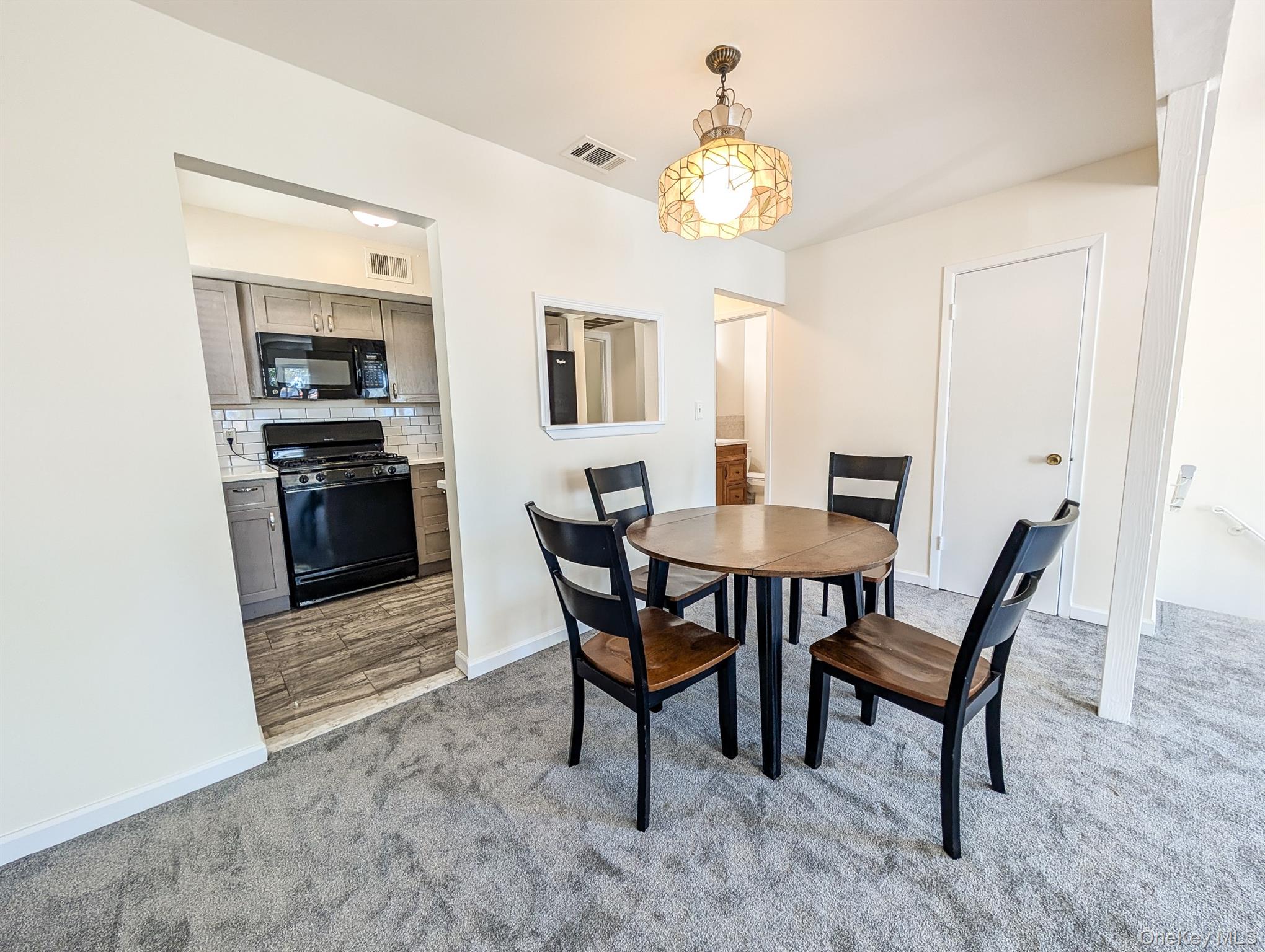 73 Rocky Point Yaphank Road, Unit 106 Rocky Point, NY 11778 - Photo 5 of 12 Dining area with light colored carpet and baseboards