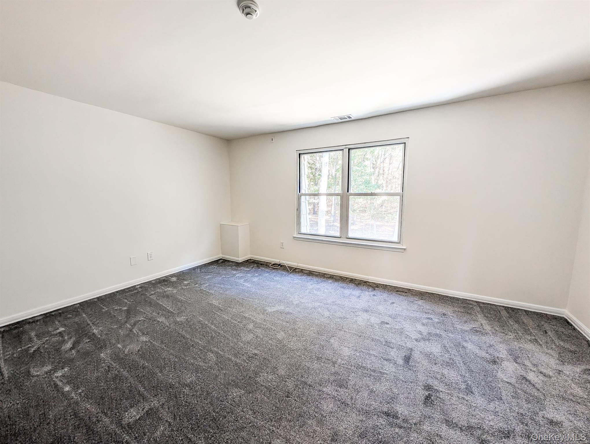 73 Rocky Point Yaphank Road, Unit 106 Rocky Point, NY 11778 - Photo 9 of 12 Spare room featuring dark colored carpet and baseboards