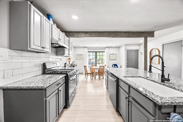 a kitchen with granite countertop lots of counter top space and stainless steel appliances