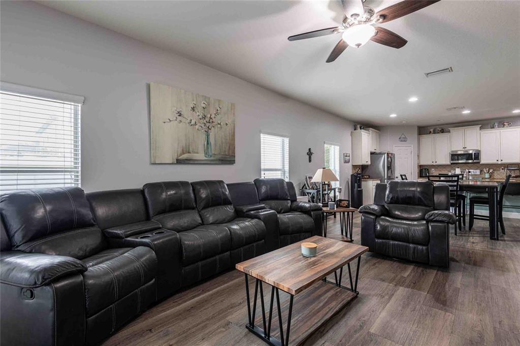 2814 Maple Brook Loop Lutz, FL 33558 - Photo 11 of 38 a living room with furniture kitchen view and a wooden floor