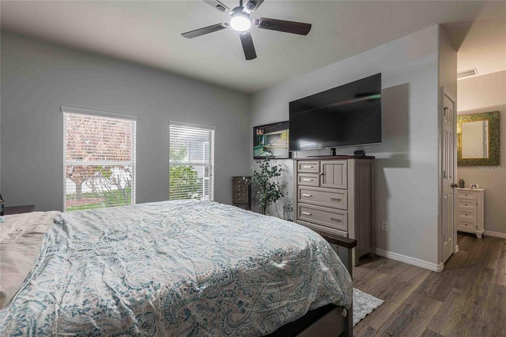 2814 Maple Brook Loop Lutz, FL 33558 - Photo 13 of 38 a bedroom with a bed and a flat screen tv