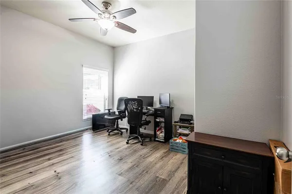 a view of a workspace with furniture and a window