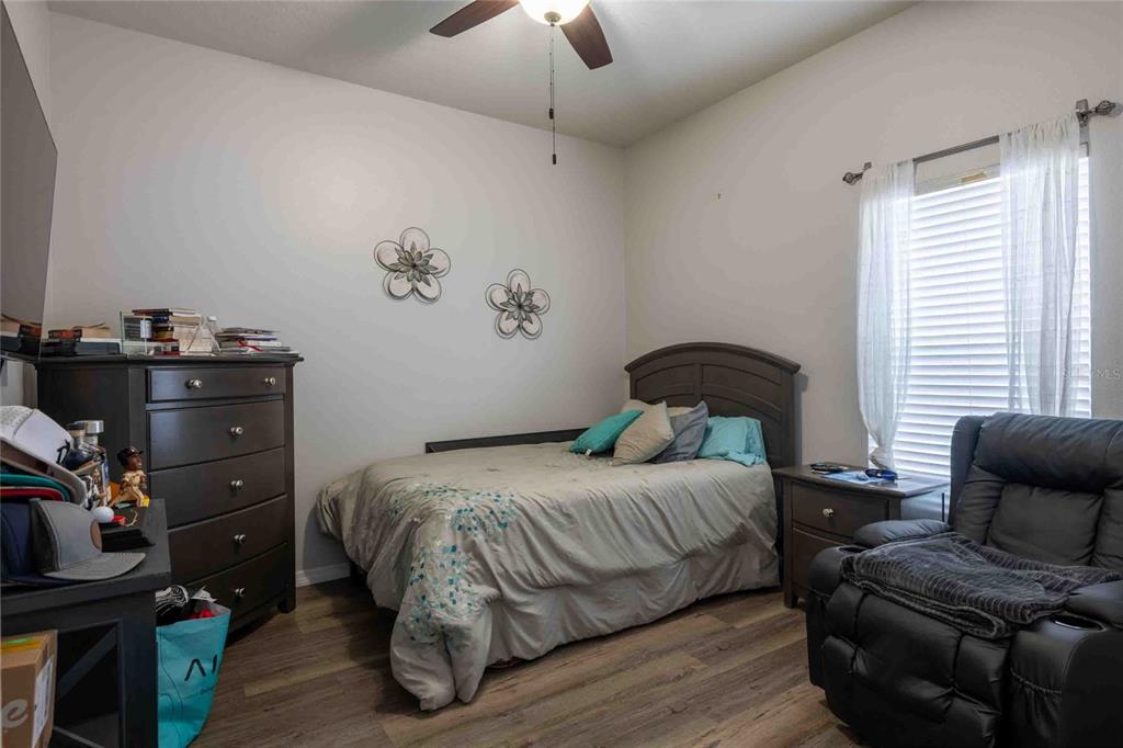 2814 Maple Brook Loop Lutz, FL 33558 - Photo 17 of 38 a bedroom with a bed and wooden floor