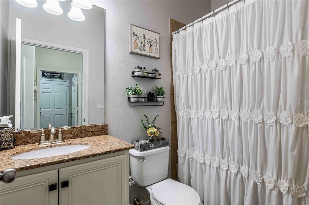 2814 Maple Brook Loop Lutz, FL 33558 - Photo 18 of 38 a bathroom with a granite countertop sink and a toilet