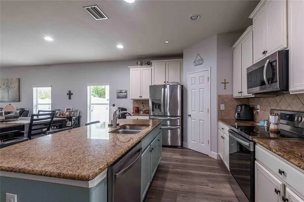 a kitchen with refrigerator stove microwave and sink