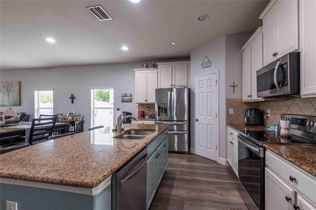 2814 Maple Brook Loop Lutz, FL 33558 - Photo 4 of 38 a kitchen with refrigerator stove microwave and sink