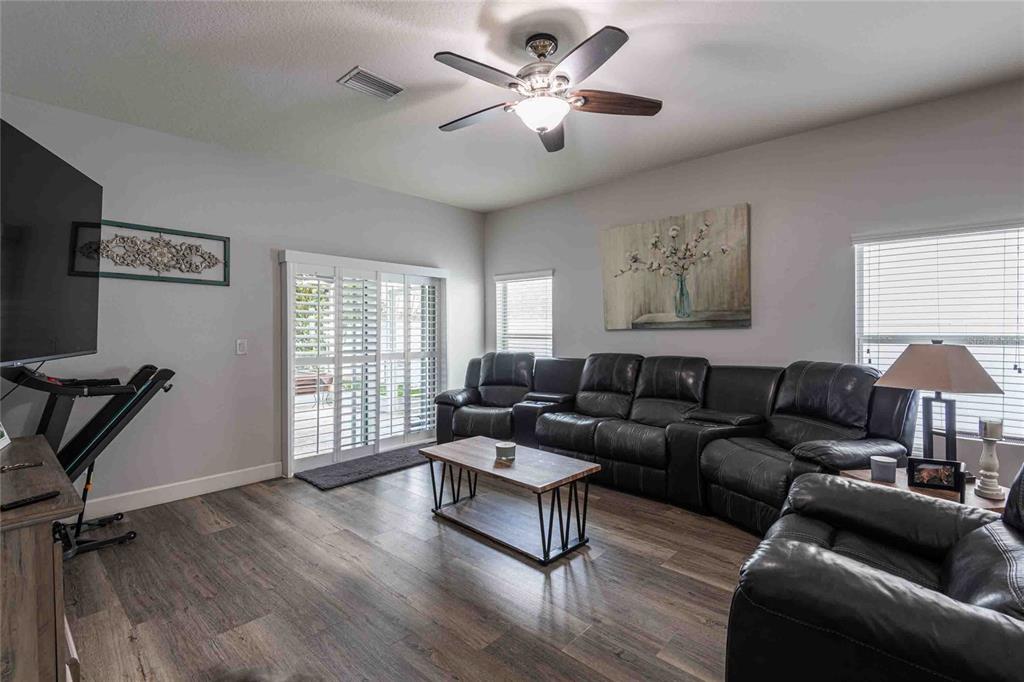 2814 Maple Brook Loop Lutz, FL 33558 - Photo 10 of 38 a living room with furniture a ceiling fan and a window