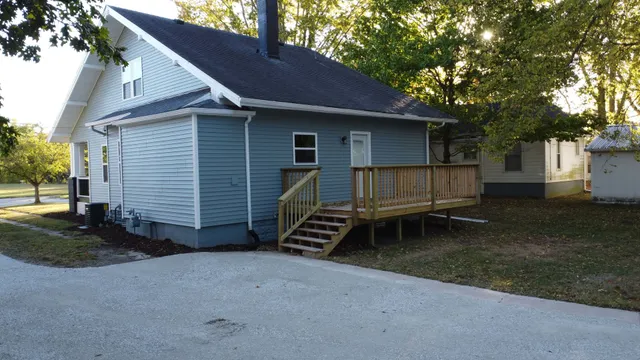 a wooden bench sitting in front of a house
