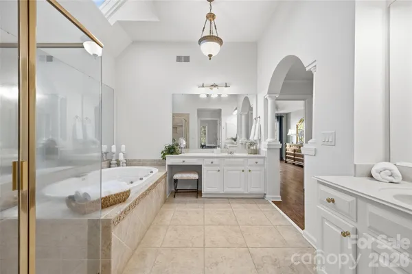 a bathroom with a tub sink and mirror