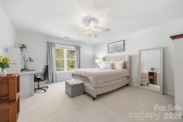 a bedroom with a bed a computer on the desk and chair