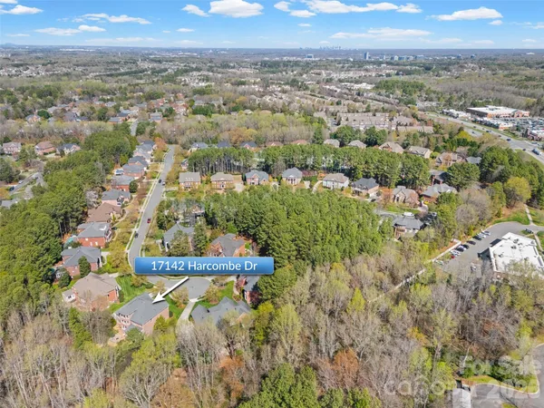 an aerial view of residential house with outdoor space and trees all around