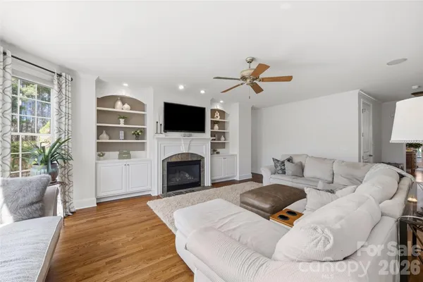 a living room with furniture a fireplace and a flat screen tv