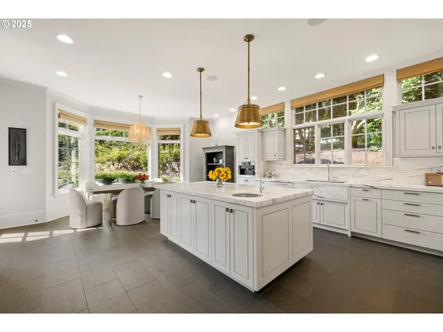 a kitchen with kitchen island granite countertop white cabinets and stainless steel appliances