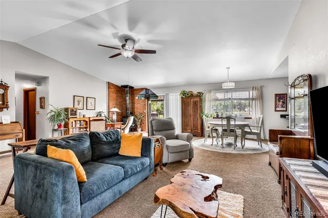 a living room with furniture ceiling fan and a window