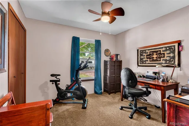 a view of a workspace with furniture and a window