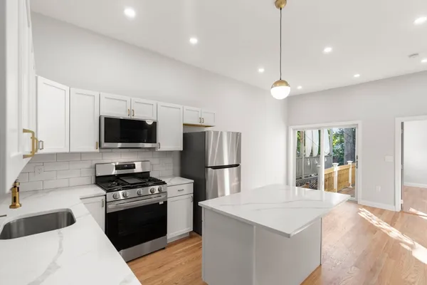 a kitchen with a sink stainless steel appliances and white cabinets