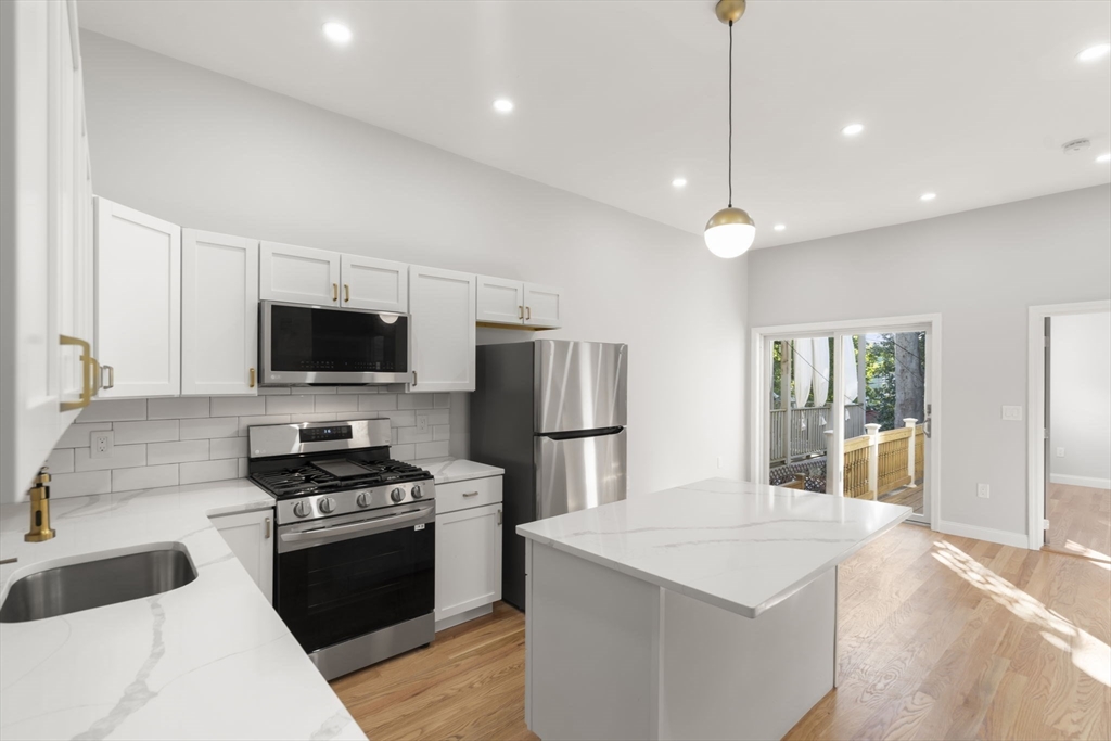 531 East 5th Street, Unit 1 Boston, MA 02127 - Photo 3 of 19 a kitchen with stainless steel appliances a stove a sink and a refrigerator