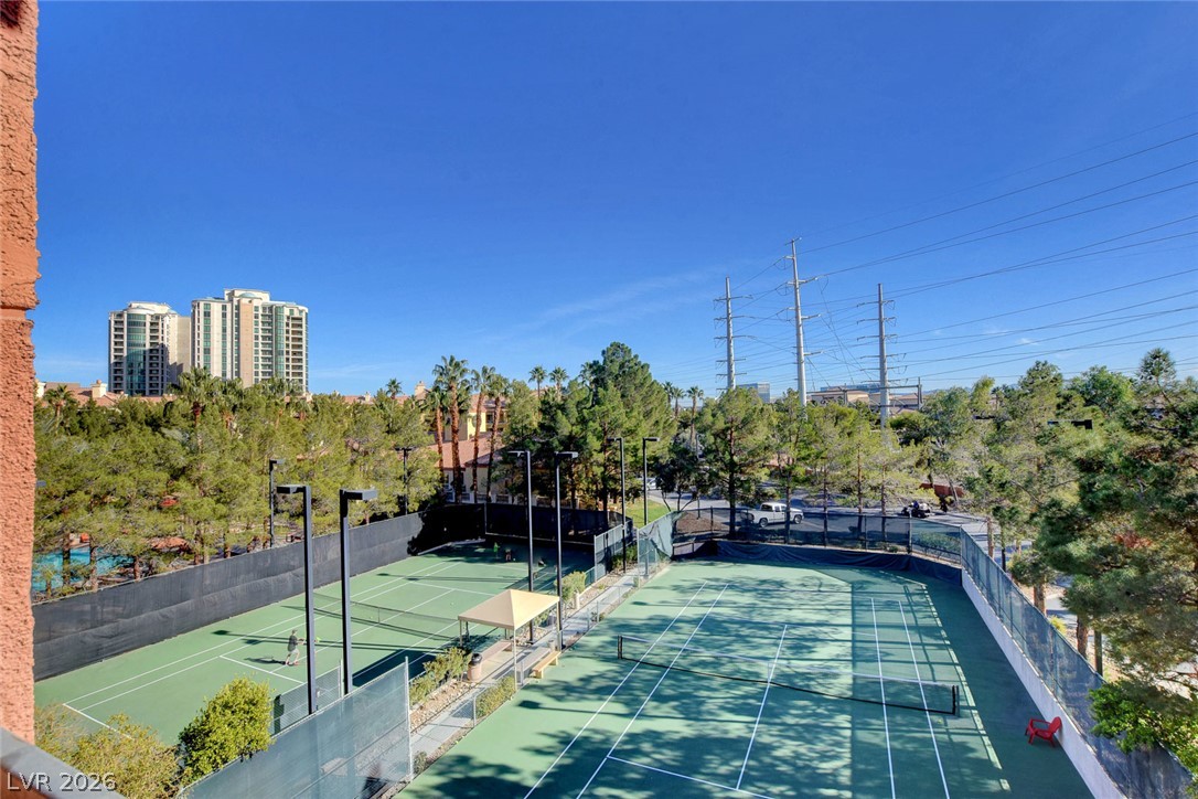 230 East Flamingo Road, Unit 106 Las Vegas, NV 89169 - Photo 54 of 66 Two tennis courts await, nestled amidst green landscaping and distant urban towers.