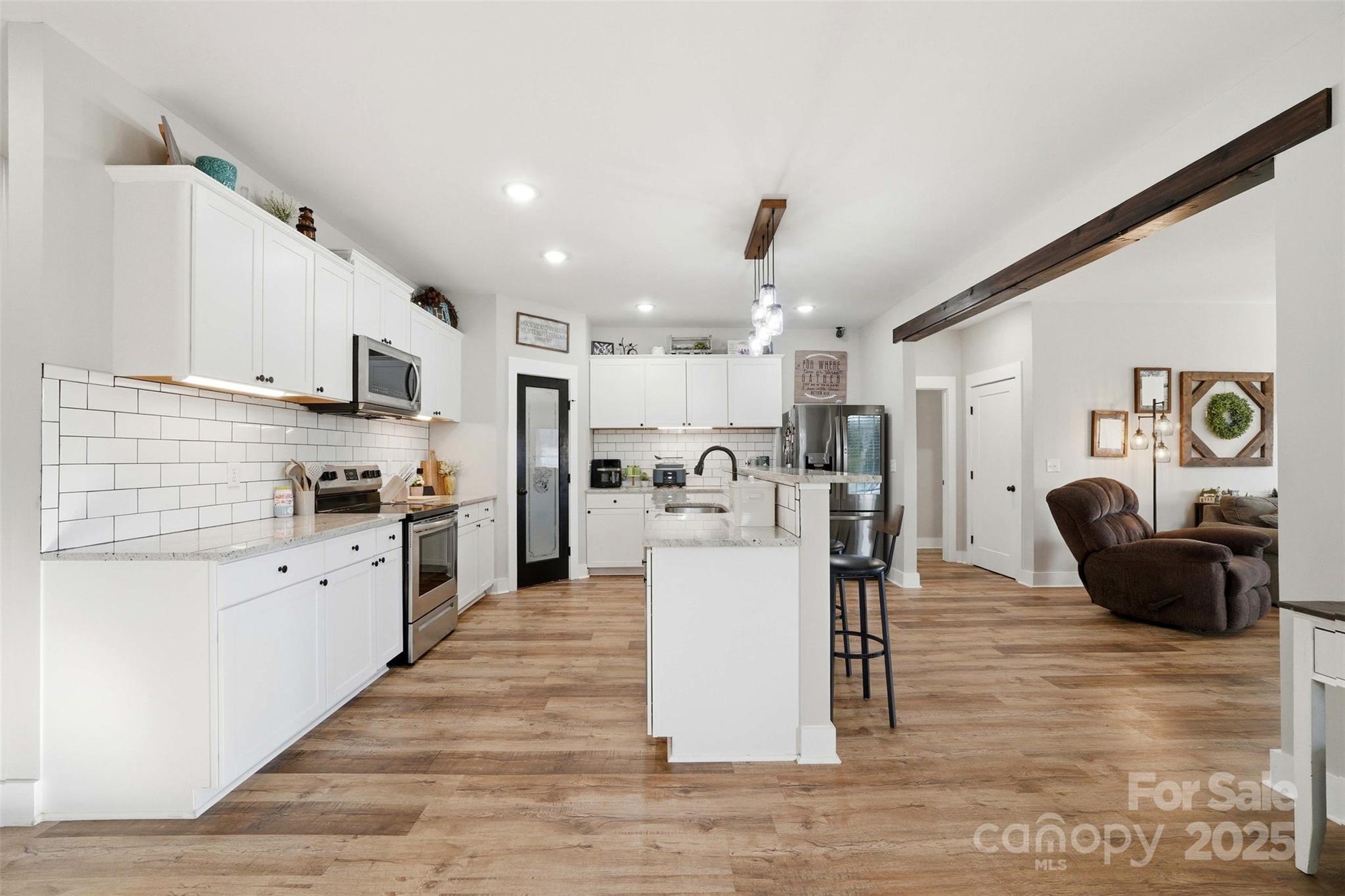 16659 Five Point Road Locust, NC 28097 - Photo 8 of 26 a kitchen with white cabinets and stainless steel appliances