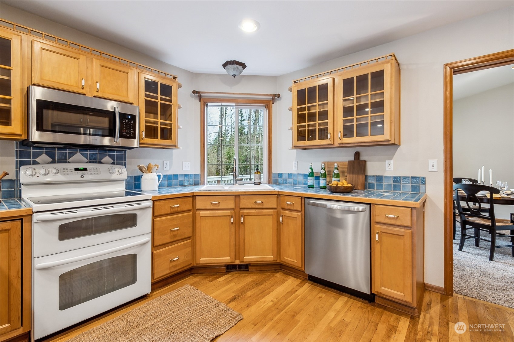 17641 Fennel Road Southeast Yelm, WA 98597 - Photo 12 of 38 a kitchen with stainless steel appliances granite countertop a stove top oven a sink dishwasher a microwave oven and a dining table with wooden floor