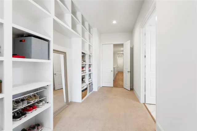 a view of walk in closet with clothes and shoes