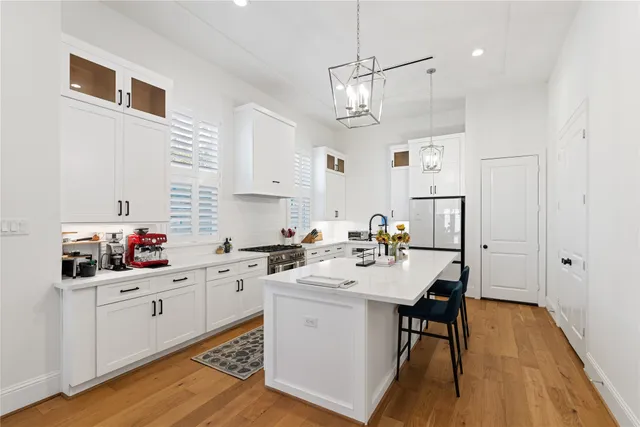 a kitchen with a sink a stove a refrigerator cabinets and wooden floor