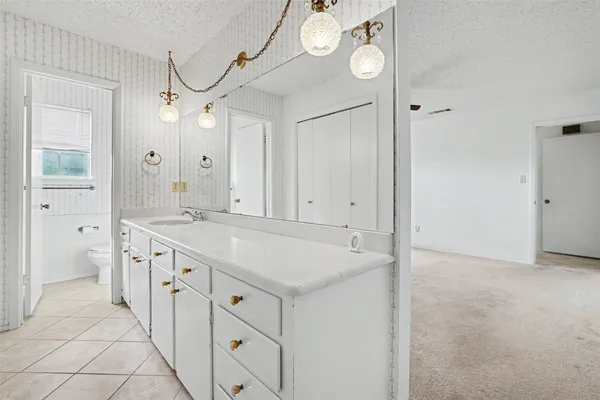 a spacious bathroom with a granite countertop sink a mirror and a shower