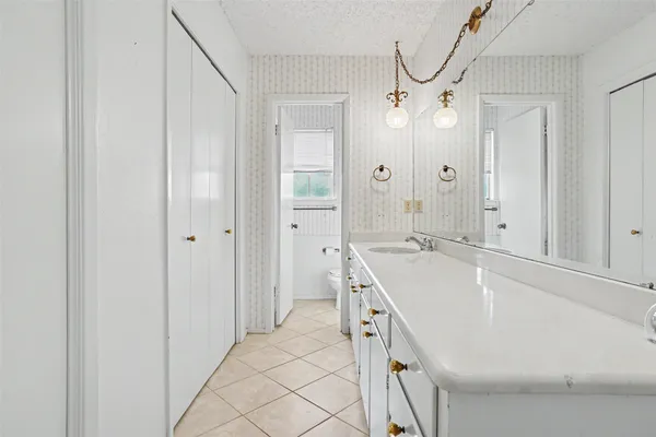 a spacious bathroom with a tub sink and mirror