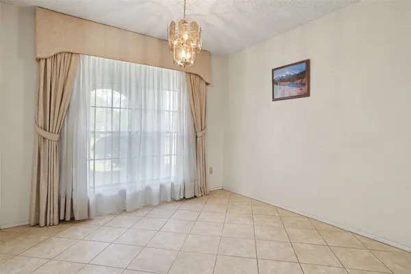 en empty room with windows and chandelier