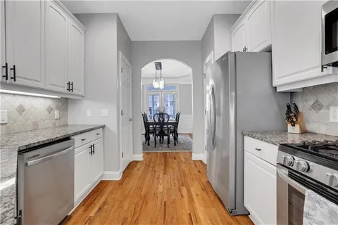 a kitchen with stainless steel appliances granite countertop a sink and stove top oven