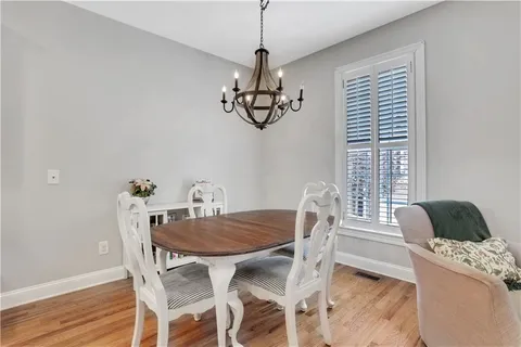 a hallway with wooden floor table and chairs